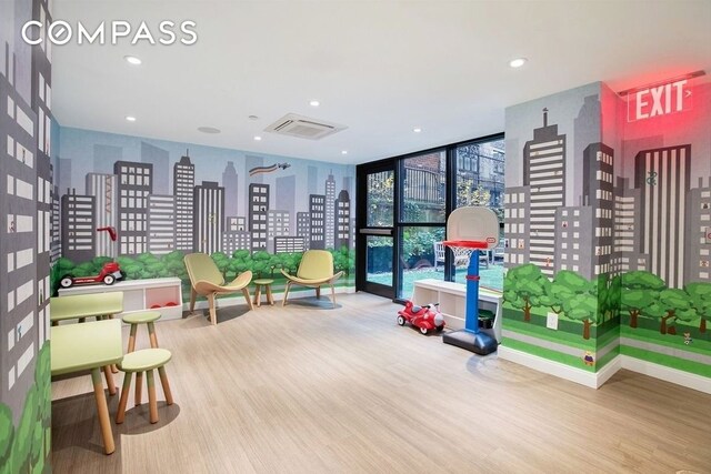 rec room featuring wood finished floors, floor to ceiling windows, and recessed lighting