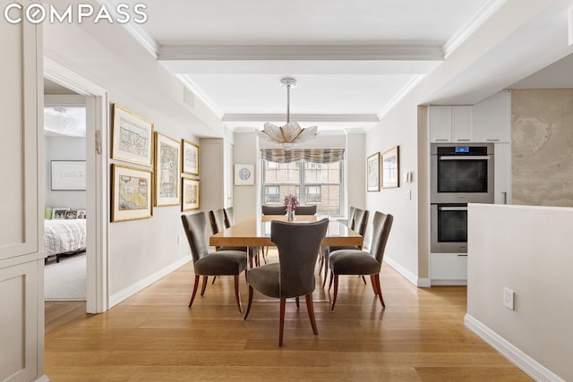 dining area with an inviting chandelier, crown molding, beam ceiling, and light hardwood / wood-style floors