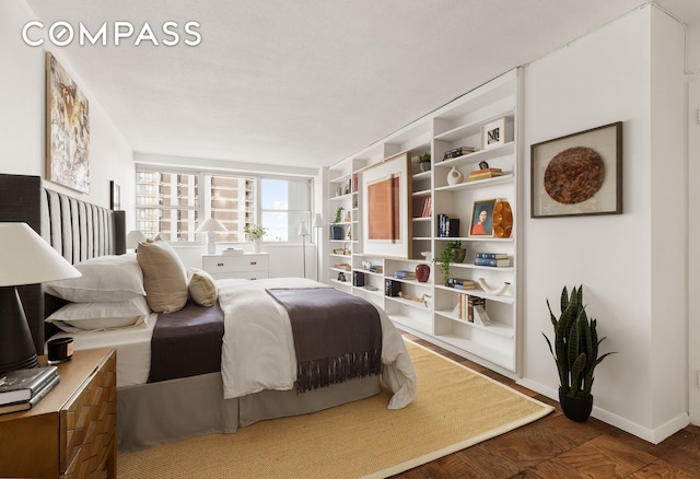 bedroom featuring dark wood-style floors and baseboards