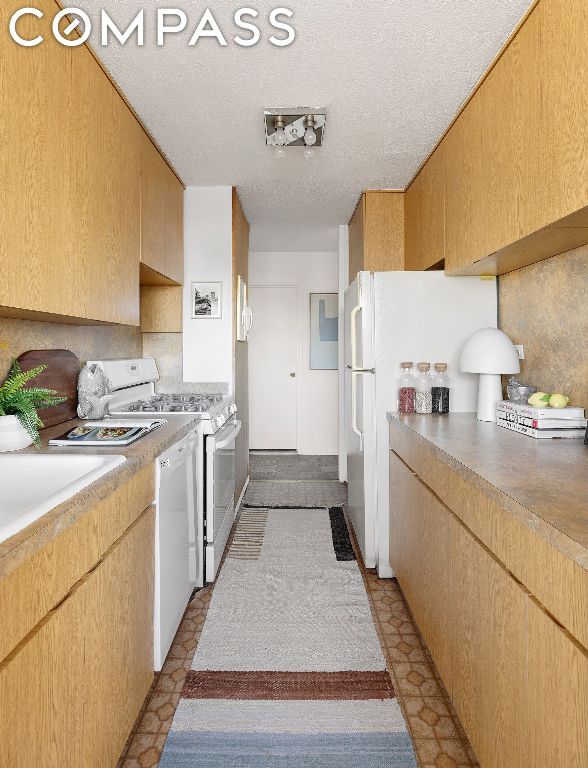 kitchen featuring white appliances and a textured ceiling