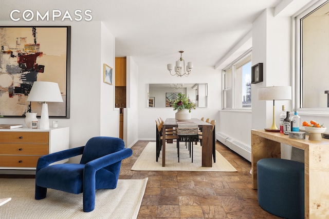 dining area featuring an inviting chandelier, baseboards, and baseboard heating