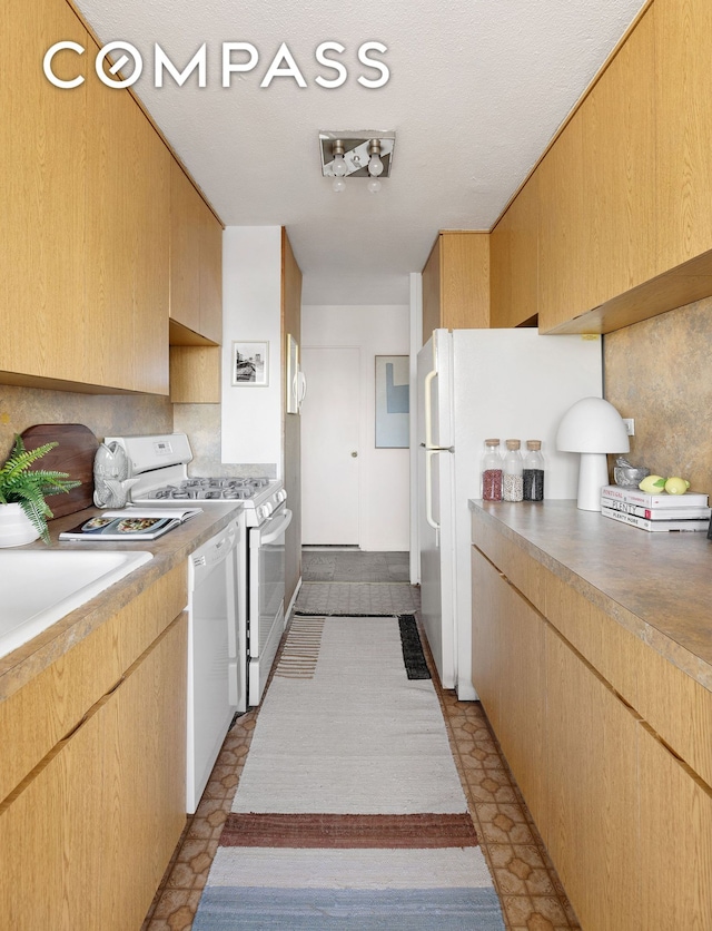 kitchen featuring white appliances, light countertops, and light brown cabinetry