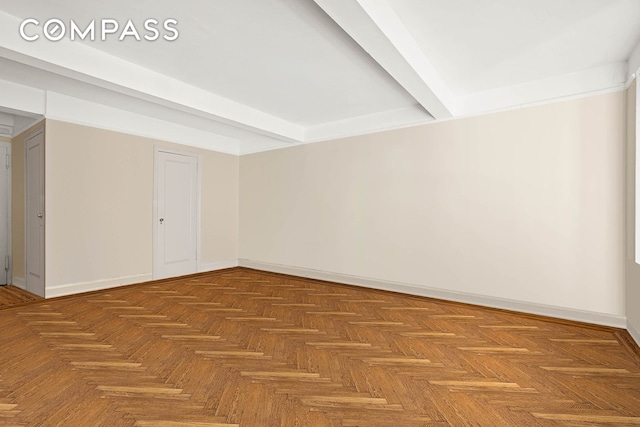 spare room with beam ceiling and baseboards