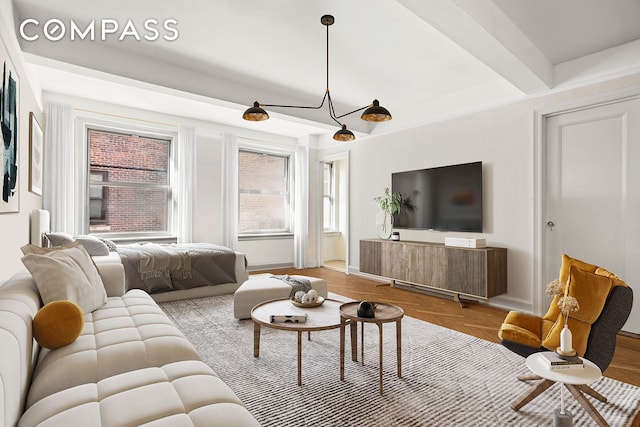 living area featuring beamed ceiling and baseboards