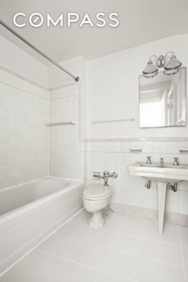 bathroom featuring toilet, shower / washtub combination, tile walls, wainscoting, and tile patterned flooring