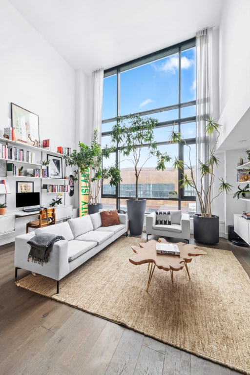 living room with wood-type flooring, expansive windows, and plenty of natural light