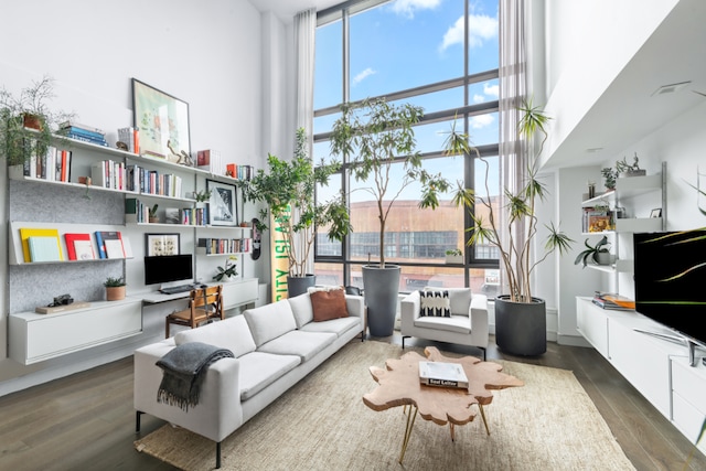 sitting room with dark hardwood / wood-style flooring, built in desk, and a high ceiling