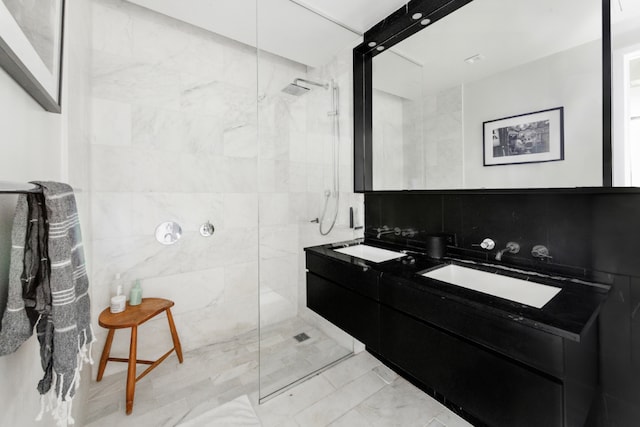 bathroom featuring a tile shower, vanity, and tile walls