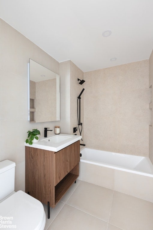 full bathroom featuring tiled shower / bath combo, vanity, tile patterned flooring, and toilet