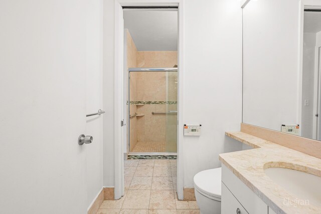 bathroom featuring vanity, toilet, tile patterned floors, and walk in shower