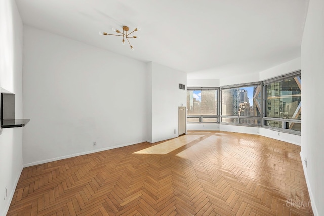 unfurnished living room featuring parquet floors and an inviting chandelier