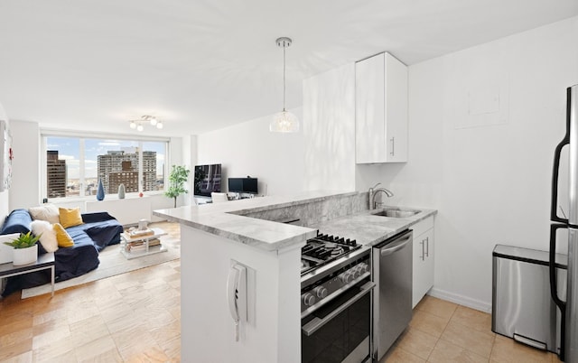 kitchen with sink, stainless steel appliances, white cabinets, decorative light fixtures, and kitchen peninsula