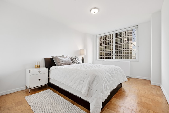 245 E 54th St Unit 30K, New York City, NY 10022 - bedroom featuring radiator heating unit and baseboards