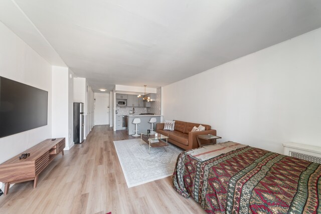 215 E 24th St Unit 823, New York City, NY 10010 - living room with light hardwood / wood-style flooring, a wall mounted air conditioner, and a wall of windows