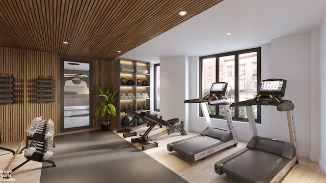 workout area with light wood-type flooring and wood ceiling