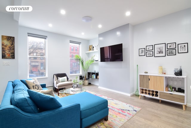 living area featuring light wood-style floors, baseboards, visible vents, and recessed lighting