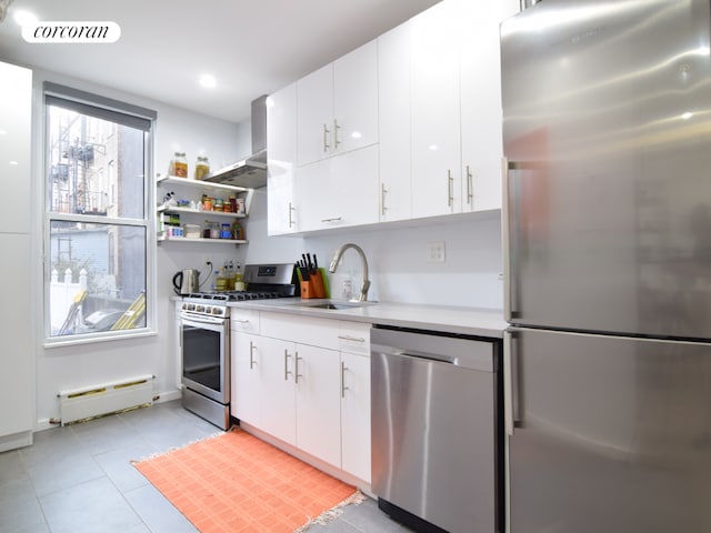 kitchen featuring a baseboard radiator, stainless steel appliances, and white cabinets