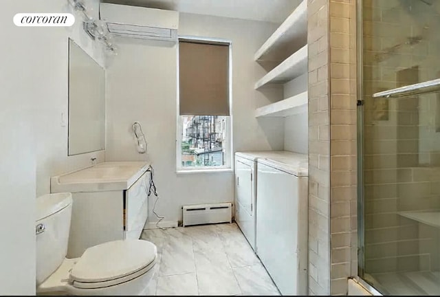 bathroom with vanity, walk in shower, a baseboard heating unit, washing machine and clothes dryer, and toilet