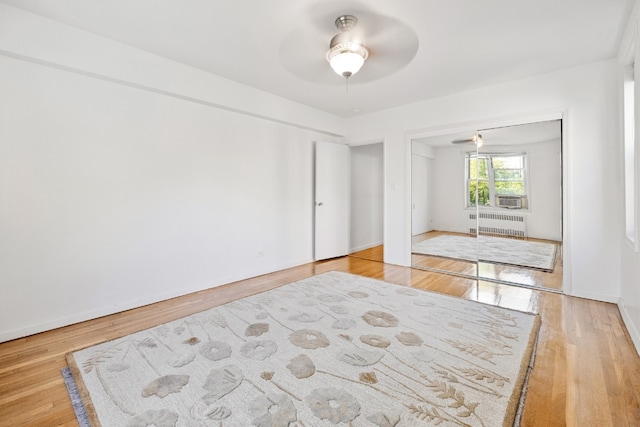 interior space featuring radiator, hardwood / wood-style floors, a closet, and ceiling fan