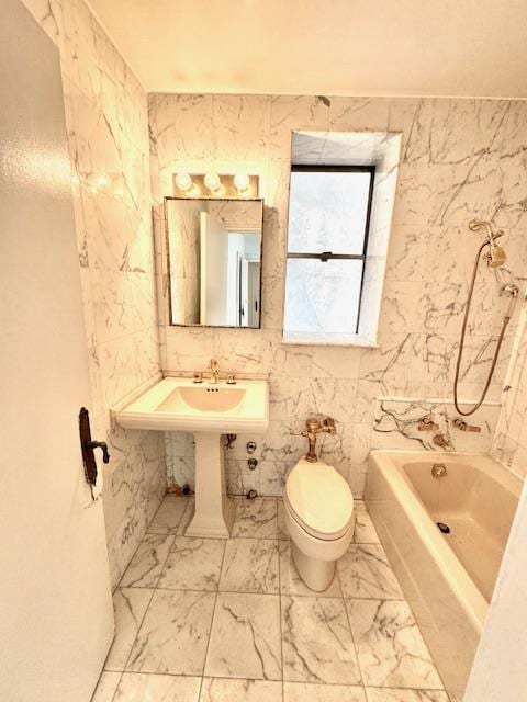 bathroom with toilet, marble finish floor, and a tub