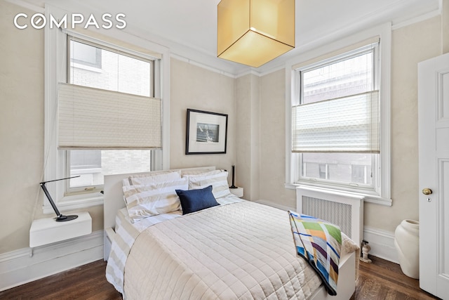 bedroom with radiator and wood finished floors