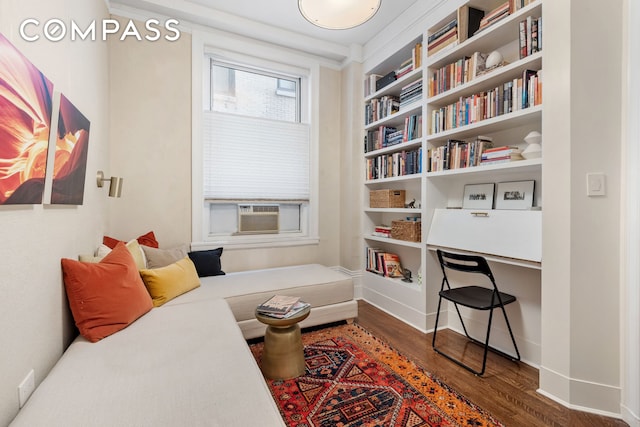 sitting room with baseboards, built in desk, dark wood finished floors, and cooling unit