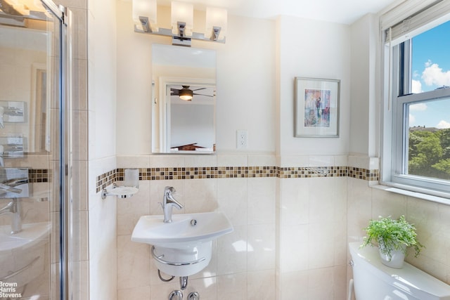 bathroom featuring a stall shower, toilet, and tile walls