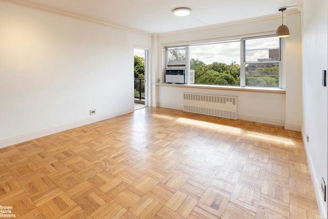 spare room featuring radiator heating unit, cooling unit, baseboards, and a wealth of natural light