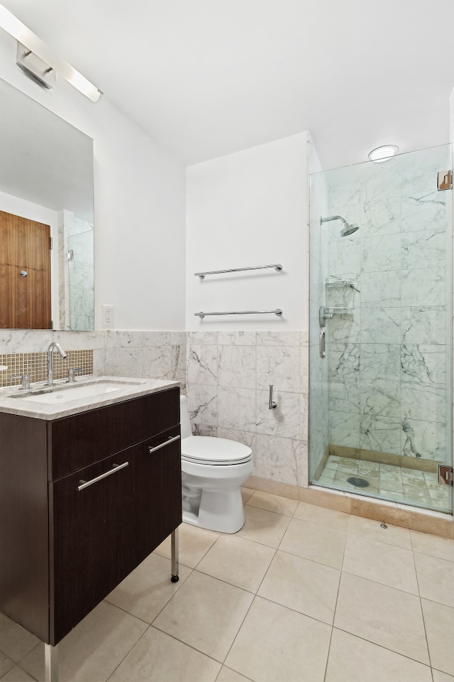 261 W 28th St Unit 3C, New York City, NY 10001 - bathroom with vanity, a marble finish shower, toilet, a wainscoted wall, and tile patterned floors