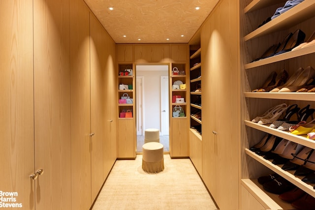 walk in closet featuring light colored carpet