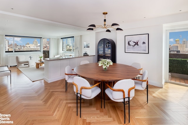 dining area featuring a notable chandelier and light parquet floors