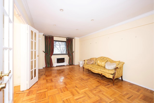 living area with baseboards, crown molding, and a fireplace
