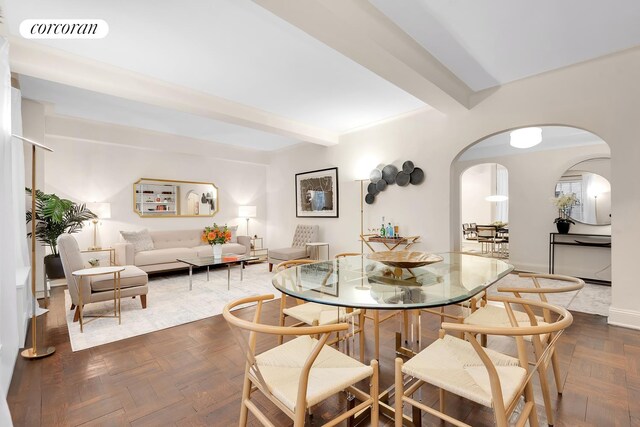 dining space featuring beam ceiling and dark parquet floors