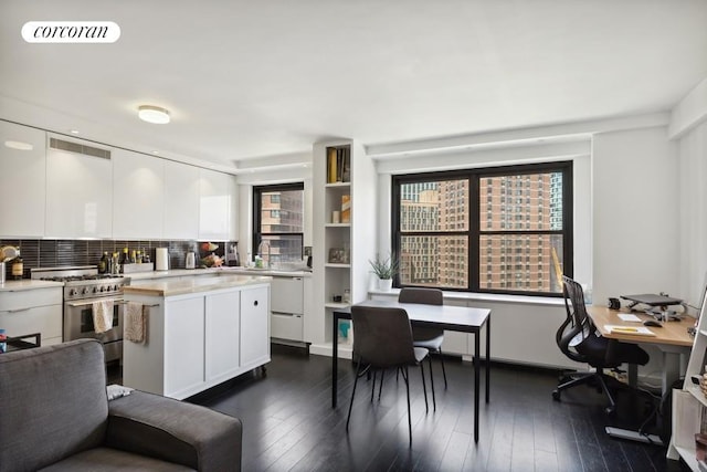 kitchen featuring visible vents, high end stove, white cabinets, and light countertops