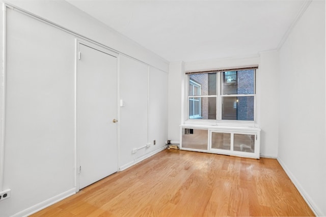 unfurnished room featuring radiator and hardwood / wood-style floors