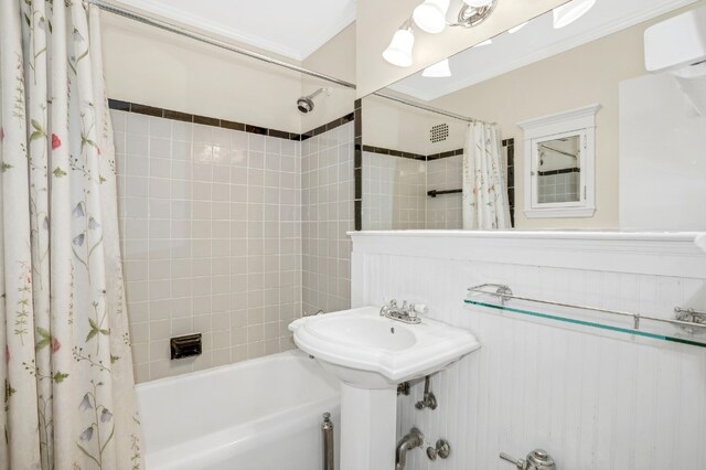 bathroom with a wall mounted air conditioner, sink, and shower / bath combo