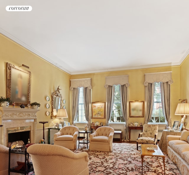 living area featuring crown molding, visible vents, a fireplace, and wood finished floors