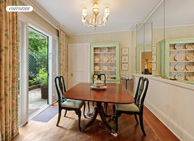 dining area featuring crown molding, a chandelier, and hardwood / wood-style floors