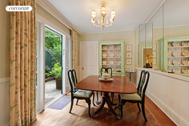 dining room featuring hardwood / wood-style floors, ornamental molding, and a chandelier