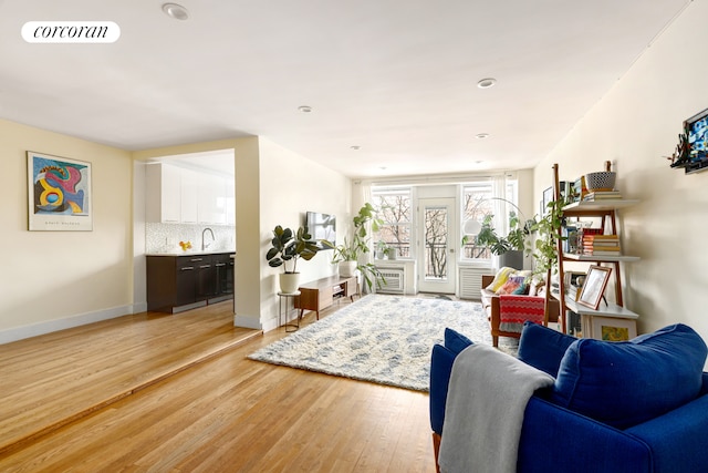living area with light wood finished floors, baseboards, and recessed lighting