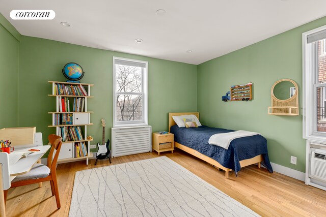 bedroom with wood finished floors, baseboards, and recessed lighting