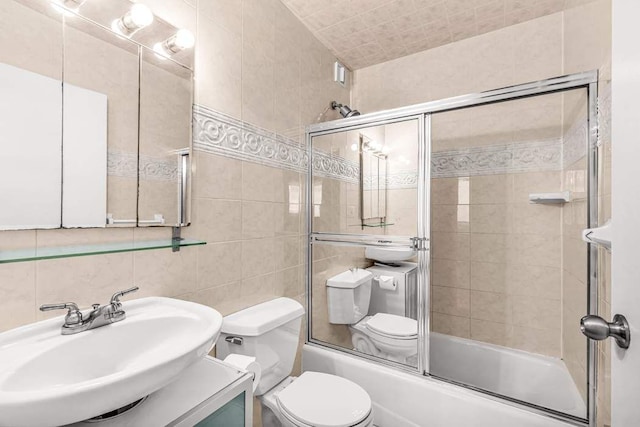 301 E 45th St Unit 10E, New York City, NY 10017 - full bathroom with combined bath / shower with glass door, tile walls, backsplash, vanity, and toilet