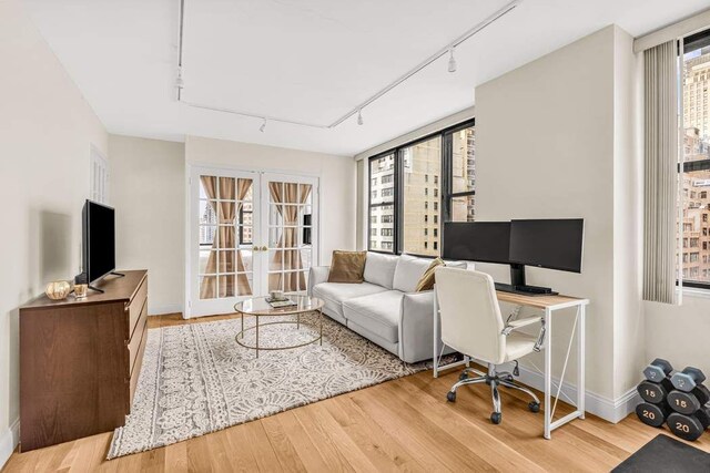 301 E 45th St Unit 10E, New York City, NY 10017 - office featuring french doors, track lighting, and light hardwood / wood-style flooring