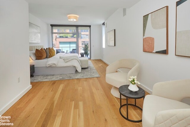 bedroom with hardwood / wood-style floors and expansive windows