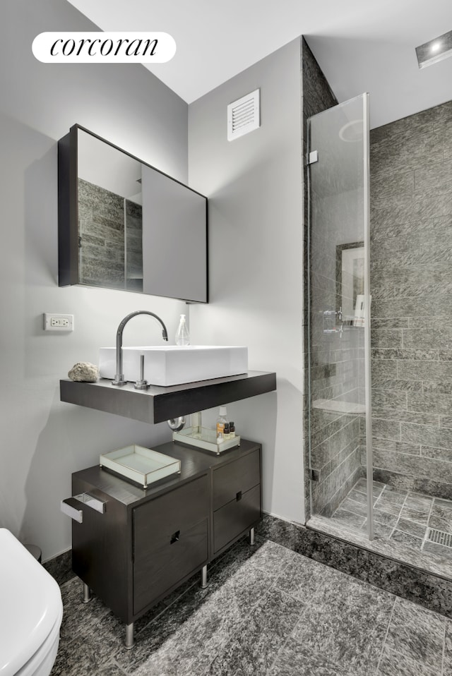 bathroom featuring toilet, a stall shower, visible vents, and vanity