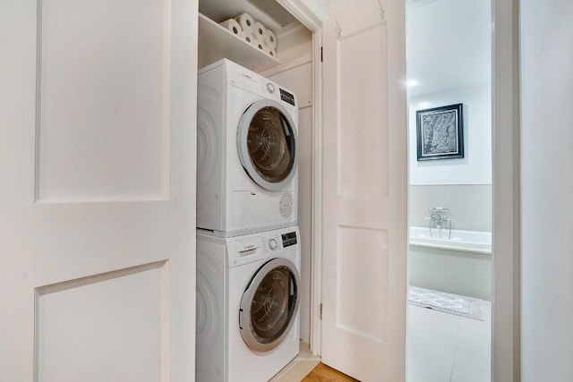 laundry area featuring stacked washer / drying machine