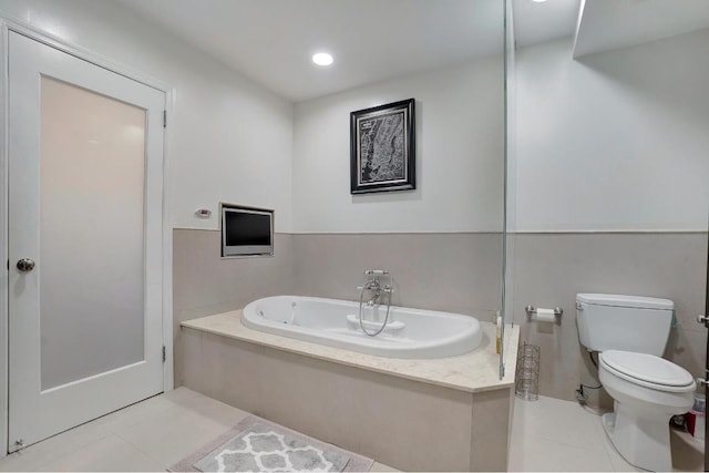 bathroom with a washtub, tile patterned floors, and toilet