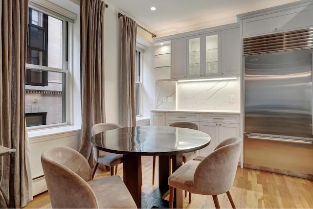 dining space featuring a baseboard heating unit and light hardwood / wood-style floors