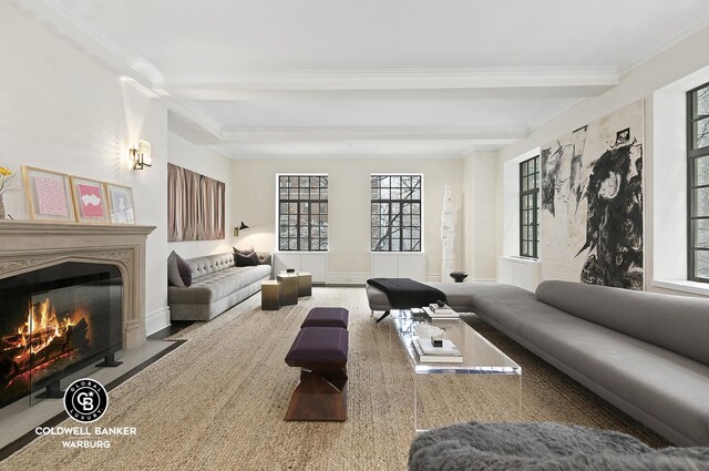living room featuring a fireplace with flush hearth, crown molding, and beam ceiling