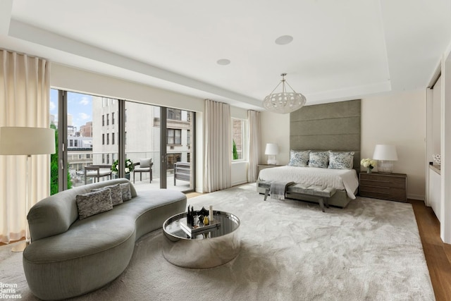 bedroom featuring a notable chandelier, hardwood / wood-style floors, multiple windows, and access to outside